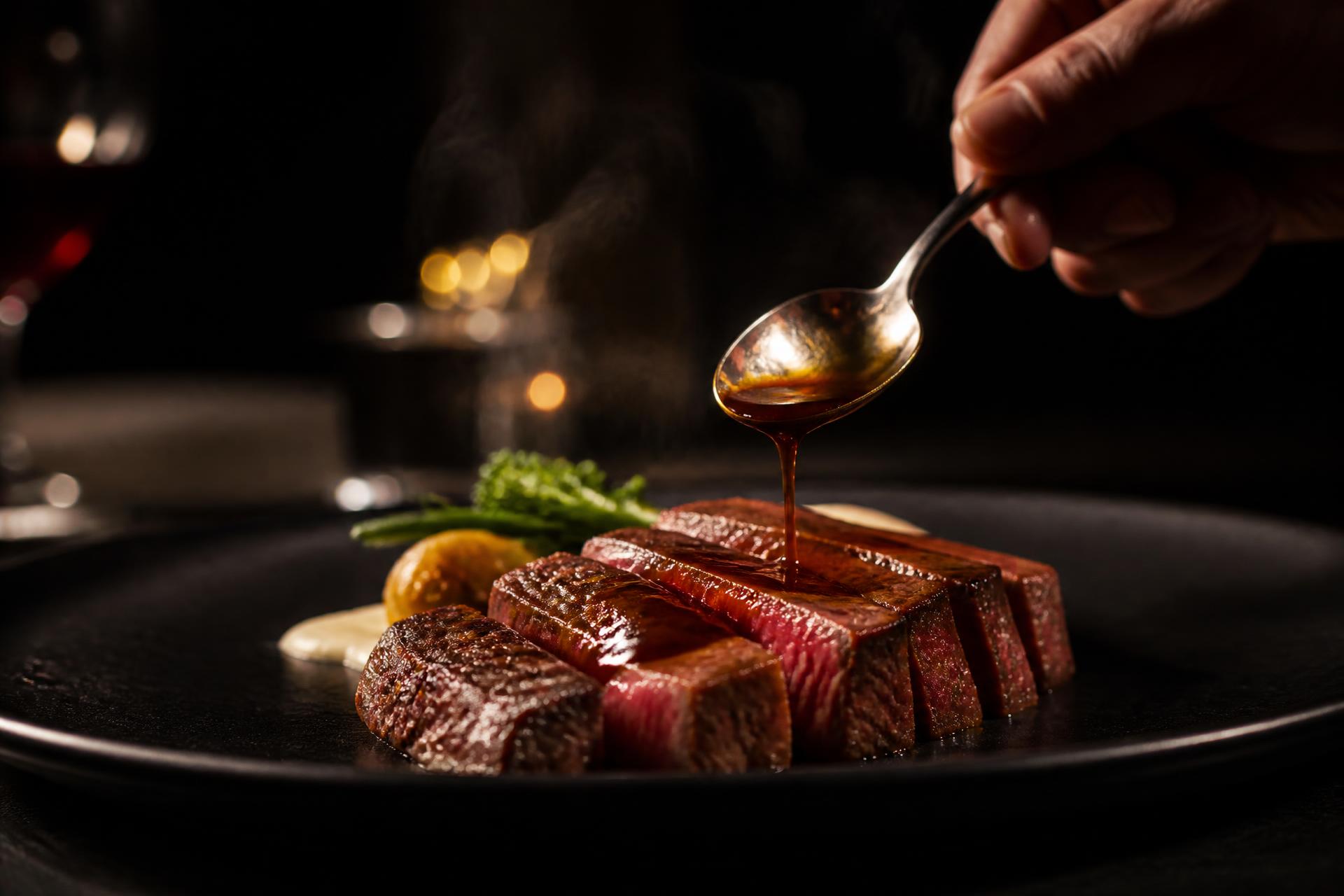 Seared Wagyu finished with sauce in a private dining setting